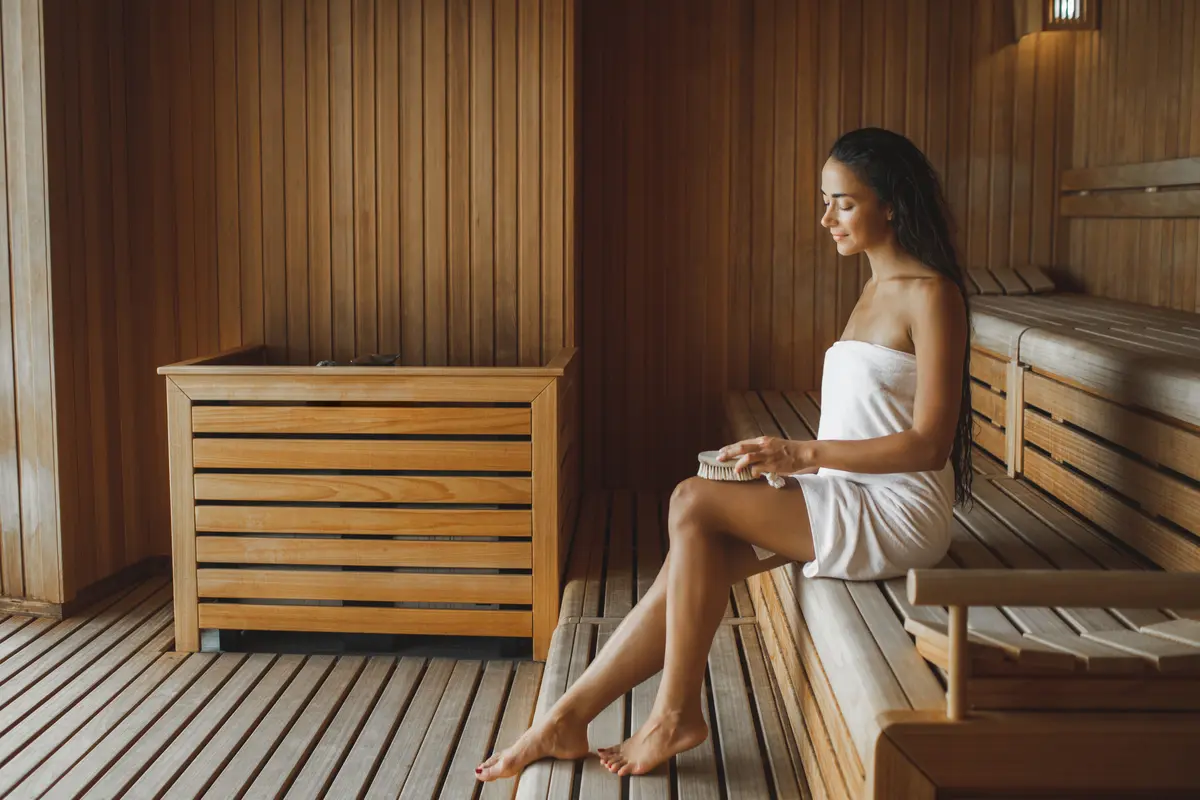 Eine Frau in der Sauna mit Handtuch