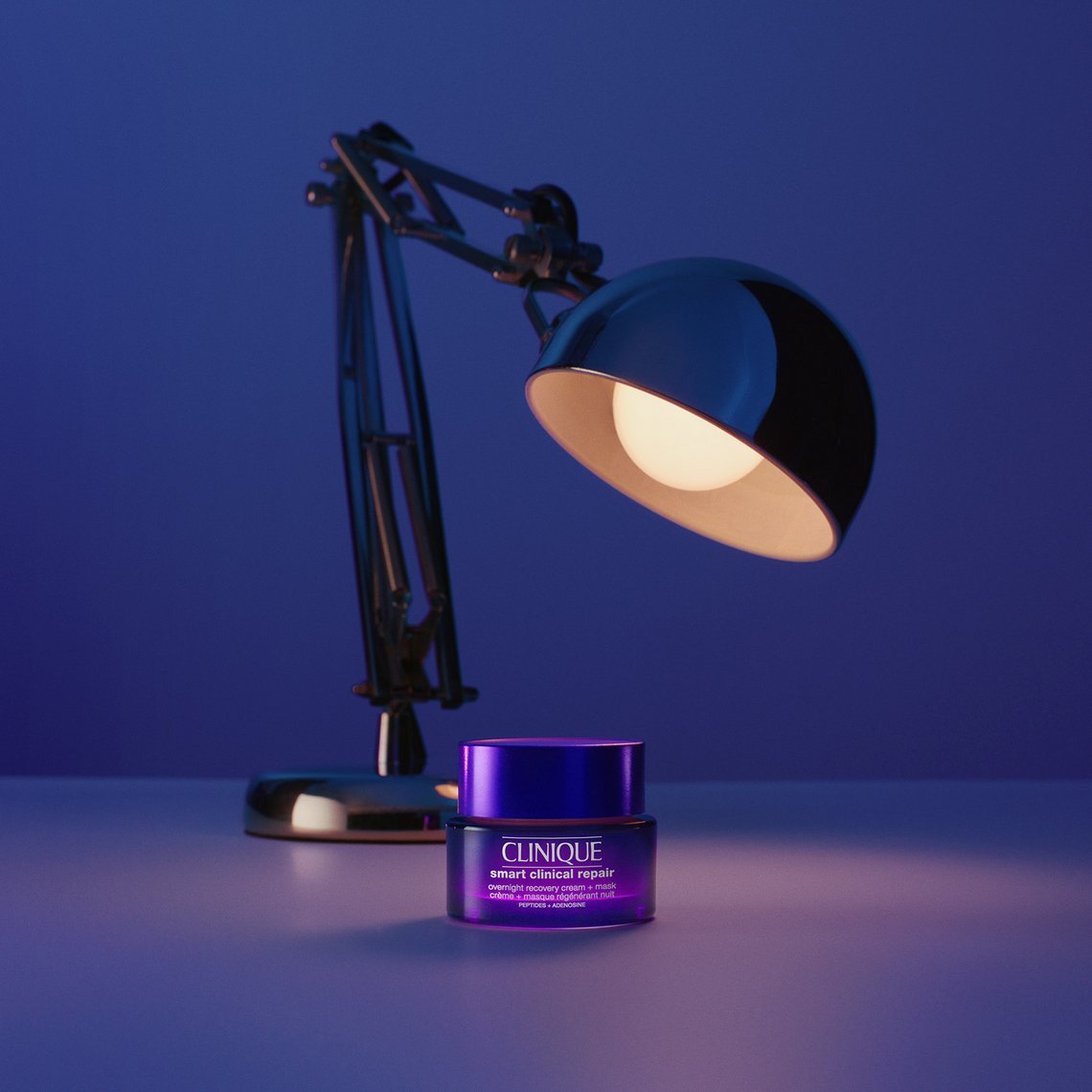 Tiegel von Clinique Overnight Recovery Cream + Mask vor einer eingeschalteten Schreibtischlampe