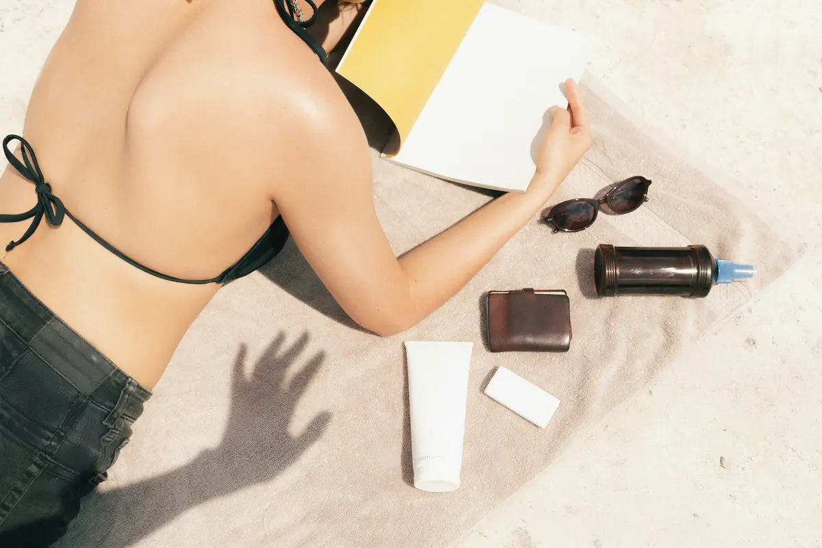 Frau am Strand mit Beauty Produkten