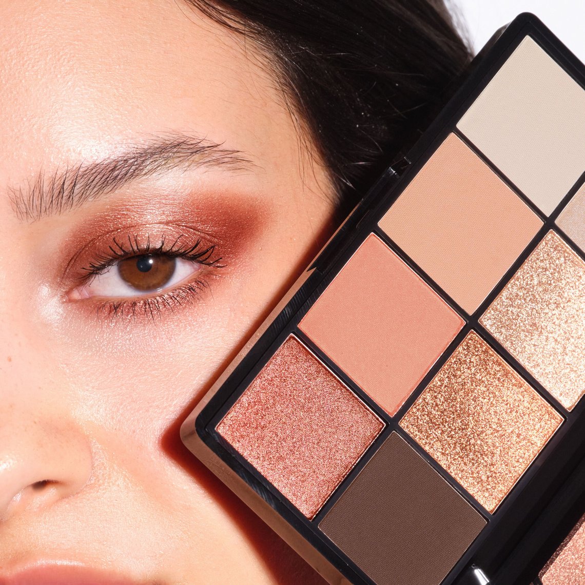 Bild zeigt Model mit Augen-Make-up, hält die Eye Palette in die Kamera