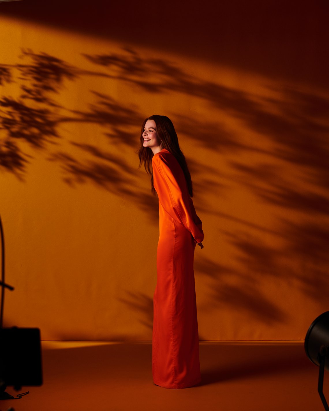 Model in einem orangefarbenen Kleid, Hintergrund orangefarbener Farbverlauf